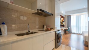 A modern kitchen with a sink, stove, and a dining area with a table and chairs.
