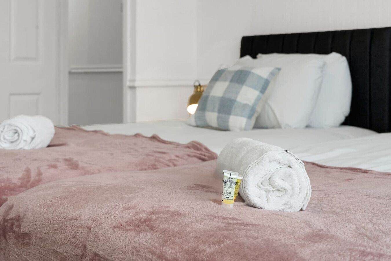 Una habitación de hotel con una cama, almohadas y toallas enrolladas.