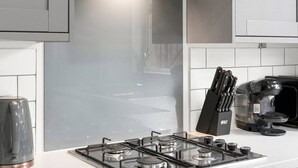 A modern kitchen with a gas stove, a coffee maker, and a knife block. - Pontcanna Paradise | 5 Mins to Centre | Fast Wifi (Pontcanna)