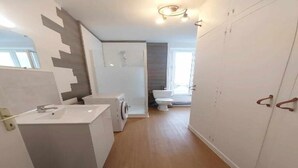 Un baño moderno con lavabo, inodoro y zona de ducha.