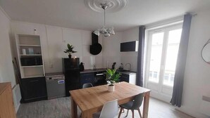 Una cocina moderna con una mesa de comedor, sillas y una planta en maceta.