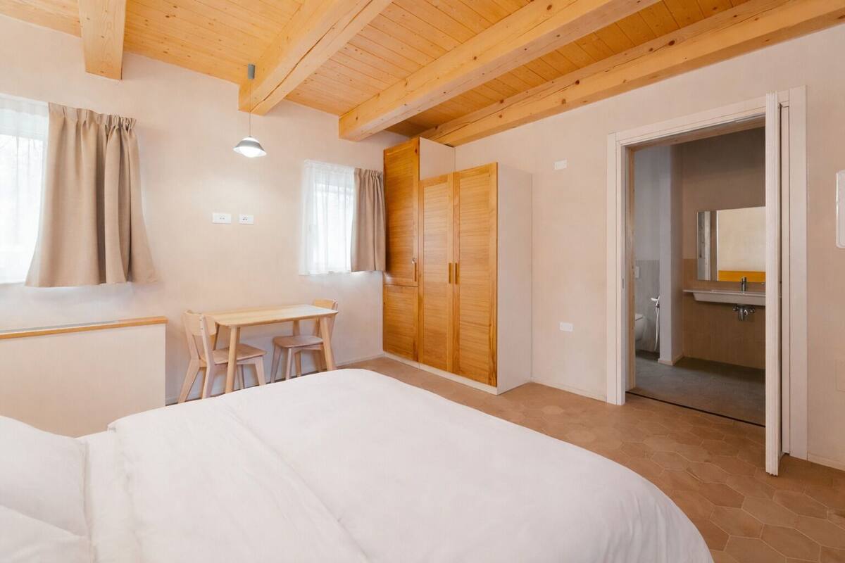 Un dormitorio con una cama, un escritorio y un armario.
