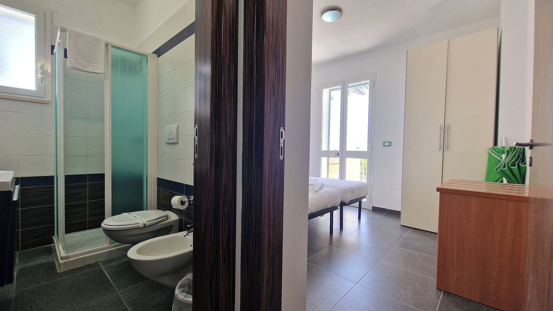 Standaard vierpersoonskamer | Badkamer | Een douche, een haardroger, een bidet, zeep