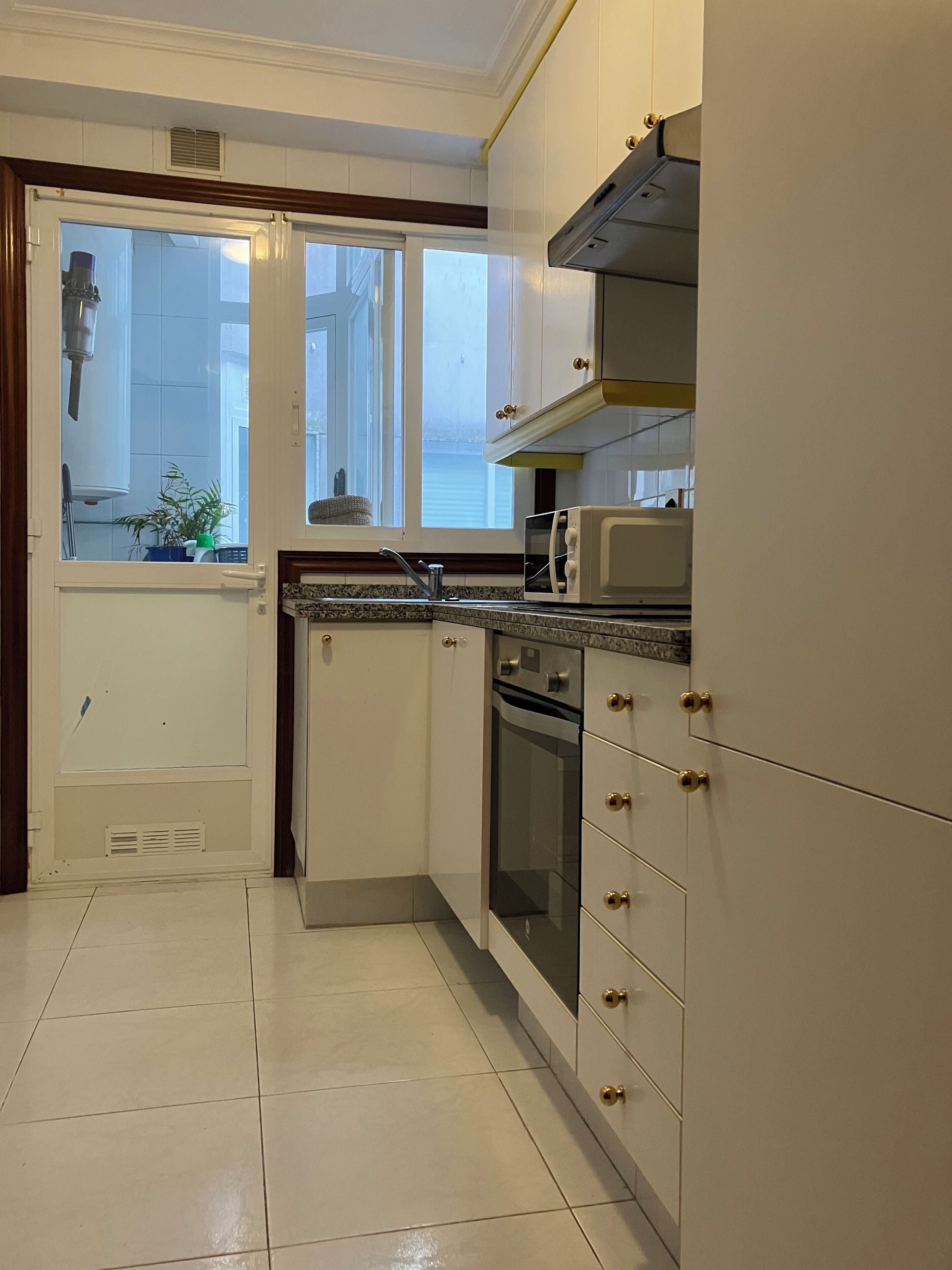 Cozinha com armários brancos, micro-ondas e forno.
