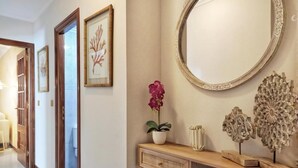 A hallway with a wooden console table, a mirror, and decorative items. - Stylish Beachside Apartment | Ocean Views, 380m from Playa de Silgar, Sanxenxo (Sanxenxo)