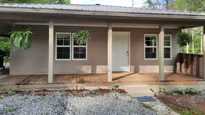A single-story house with a front porch, a door, and two windows. - Creekside Garage Getaway  (Robbinsville)