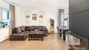 Una sala de estar moderna con un sofá modular, una mesa de centro, una estantería y un televisor de pantalla plana.