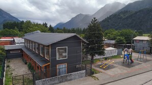 A modern building with a flat roof, large windows, and a visible door. - Plaza Araucaria Apart Hotel, Single apartment 4 p, Mañihuales, Carretera Austral (Villa Mañihuales)
