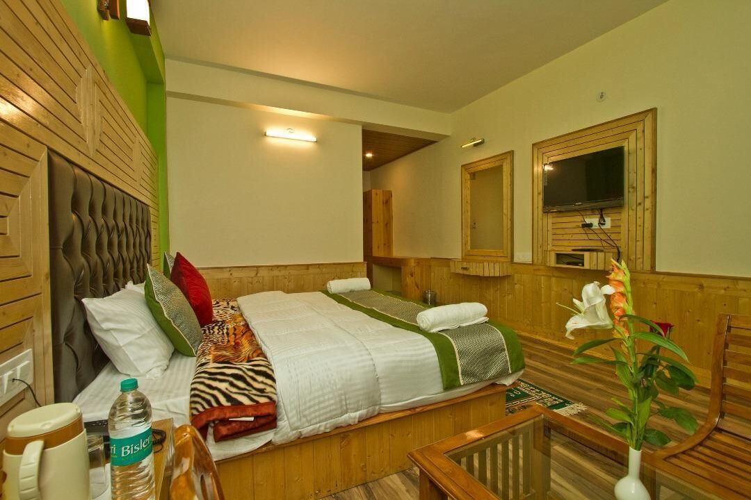 Ein Hotelzimmer mit Bett, Nachttisch, Lampe und Spiegel.