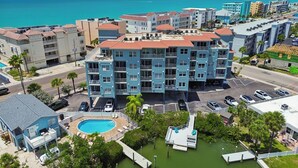 Un hôtel à plusieurs étages doté de balcons, d’une piscine et offrant une vue sur l’océan.