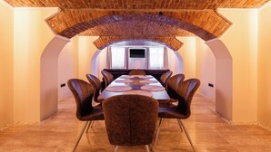 A conference room with a long table, chairs, and a brick ceiling. - The Vault Apartment | Unique Stay | Sibiu Center (Sibiu)
