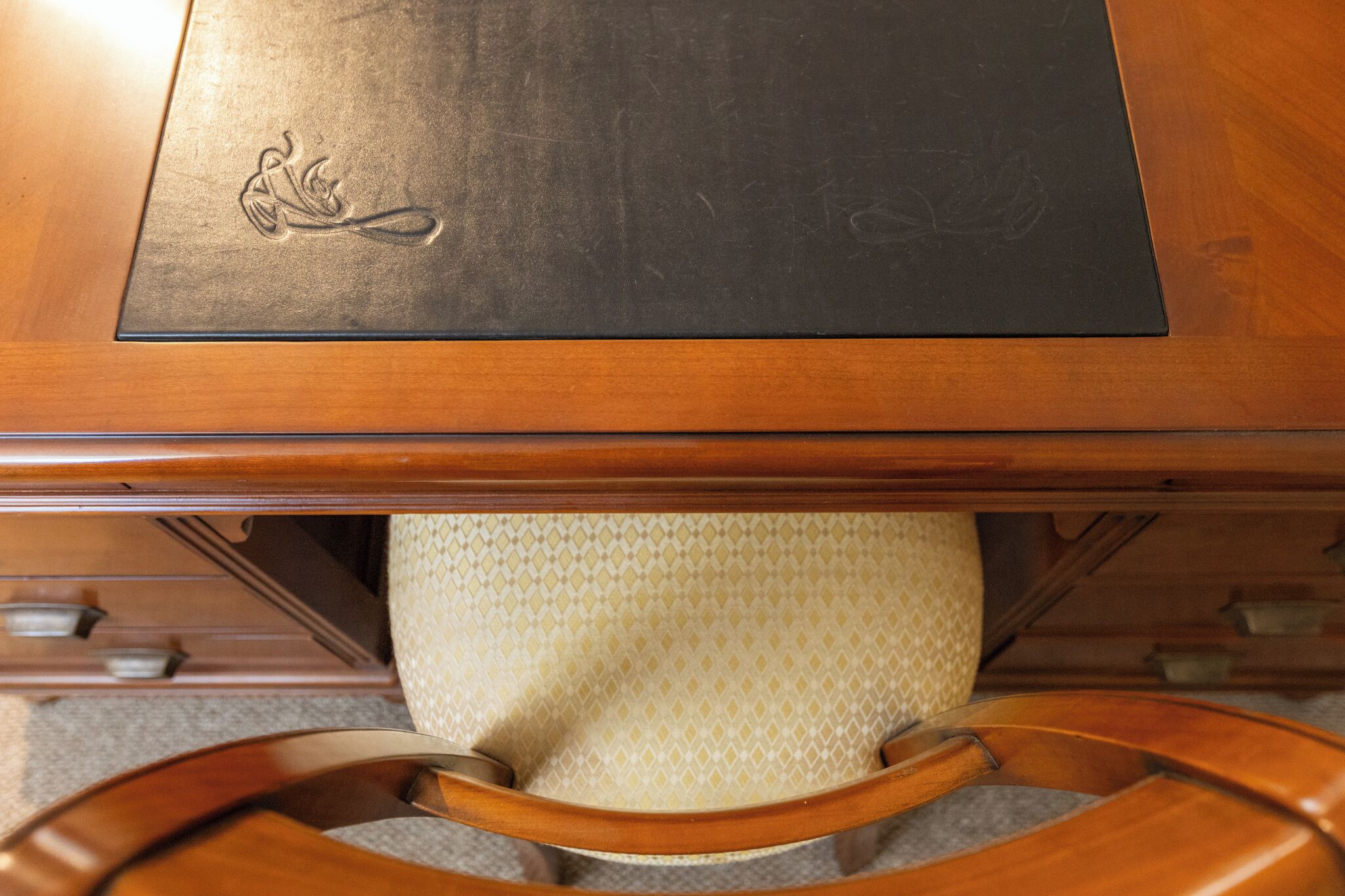 Une table en bois dont le plateau présente une texture particulière et une chaise dont l’assise est faite d’un tissage.