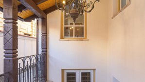 A staircase with a wooden ceiling, a chandelier, and a window. - The Vault Apartment | Unique Stay | Sibiu Center (Sibiu)