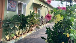 Ein Gebäude mit einem Schild für einen Roadtrip-Ort, einem überdachten Gang und verschiedenen Pflanzen.