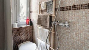 A bathroom with a toilet, a shower, and a window with a view of a tower. - Studio Solo - Opera Galeries Fayette - 1 Pax (Paris)