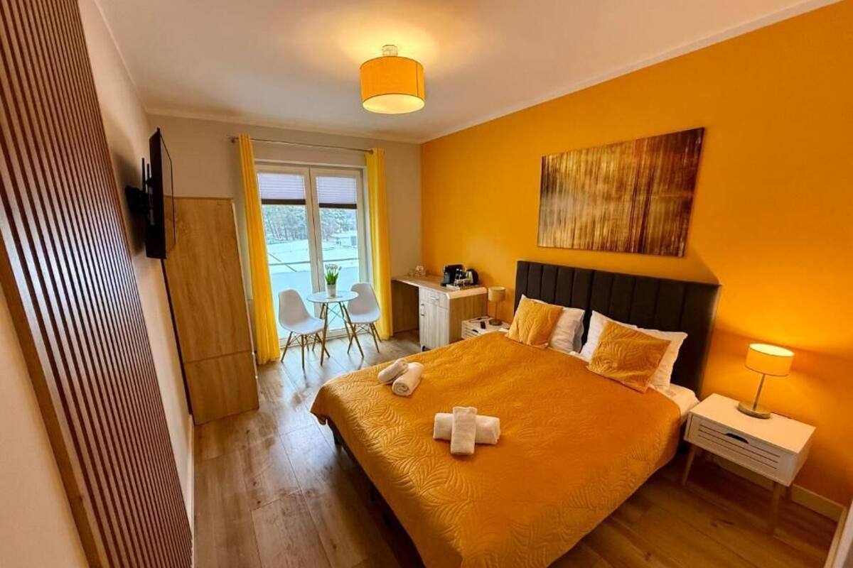 Een hotelkamer met een groot bed, een bureau, een stoel en een raam.