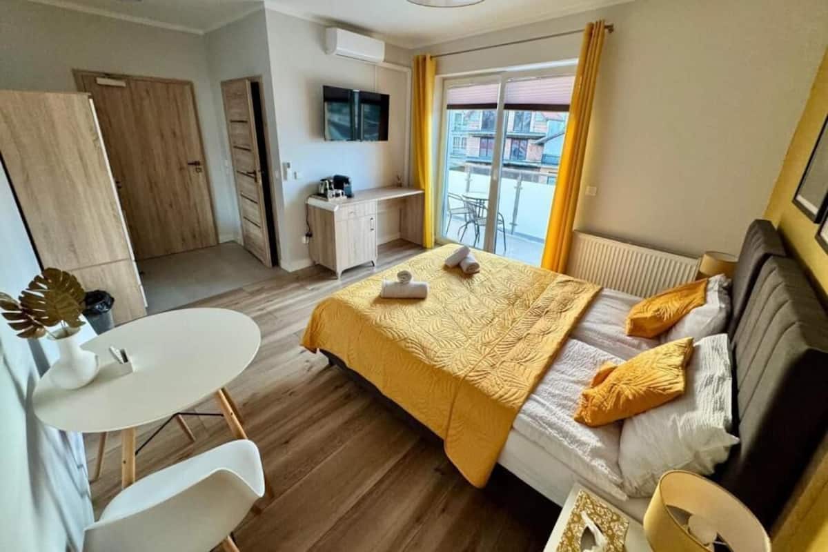 Een moderne slaapkamer met een bed, nachtkastje en uitzicht.