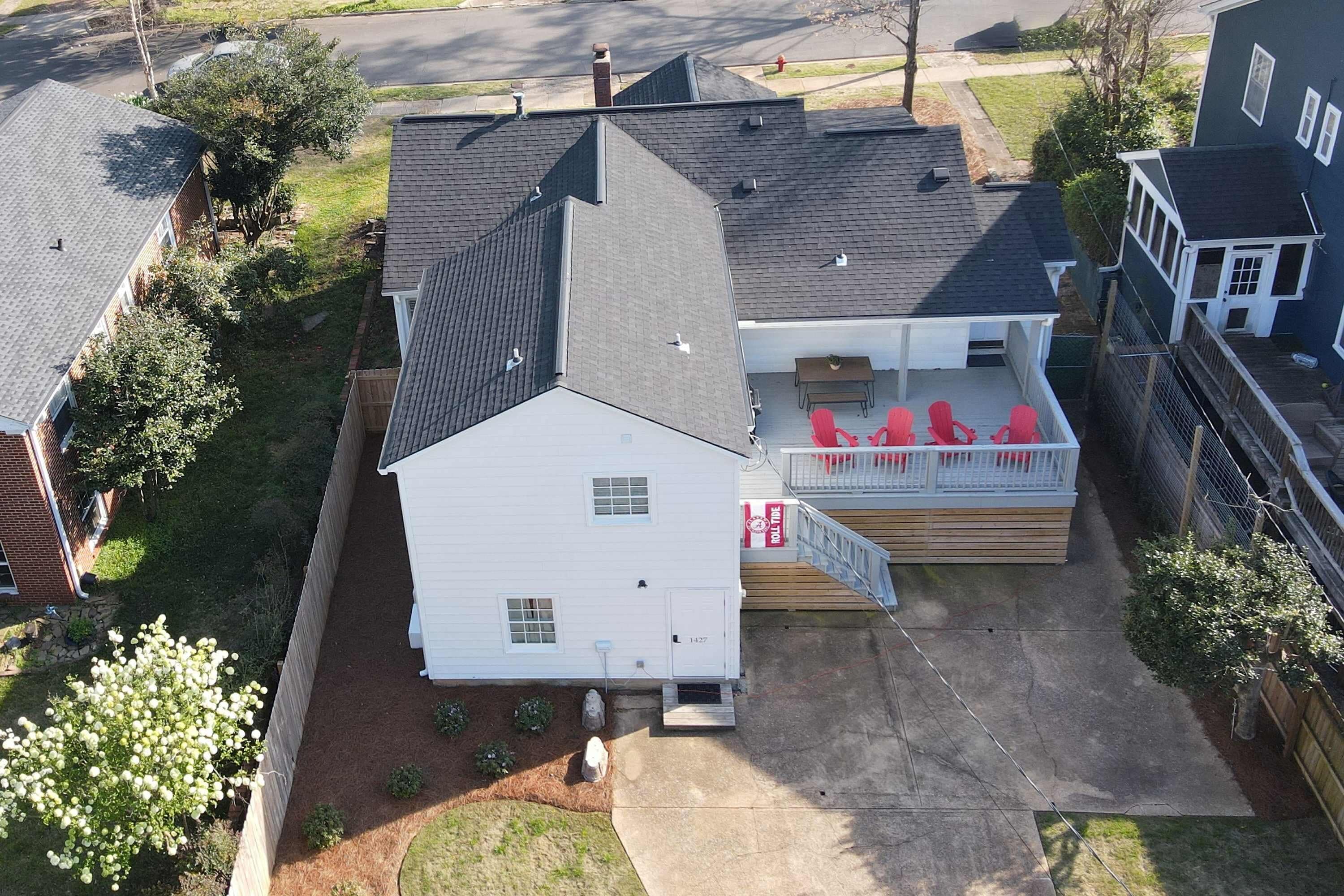 Une maison à deux étages avec un porche abrité et une petite terrasse.