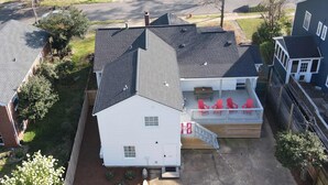 Una casa de dos pisos con un porche cubierto y una pequeña terraza.