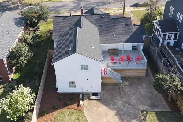 A two-story house with a covered porch and a small deck.