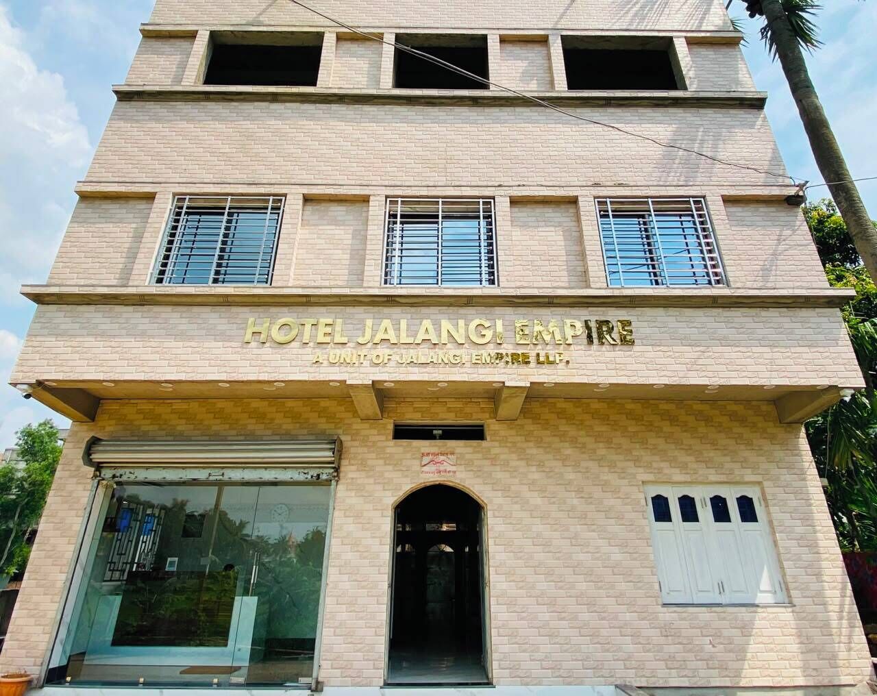 A hotel building with a sign reading 'HOTEL JALANGI EMPIRE' and a unit of Jalangi Empire LLP.