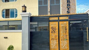Ein Gebäude mit moderner Fassade, einem auffälligen Schild mit dem Schriftzug 'Toby's' und einem dekorativen Tor mit aufwendigen Verzierungen.