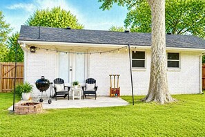 A house with a covered patio, outdoor seating, a barbecue grill, and a tree. - 2 Miles to OU • Quiet • Fenced Yard + Fire Pit (Norman)