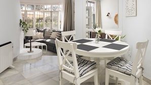 A modern living room with a round dining table, white chairs, a sofa, and a view through large windows. - AS EXT Calahonda MAR 10 (Mijas)