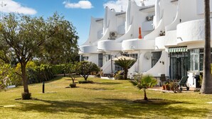 A white building with a garden in front, including a palm tree and a small tree. - AS EXT Calahonda MAR 10 (Mijas)