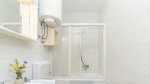 A bathroom with a toilet, sink, shower, and a small vase with flowers. - One-bedroom apartment Casa Vidasca 103 with the pool and the private balcony (Novalja)