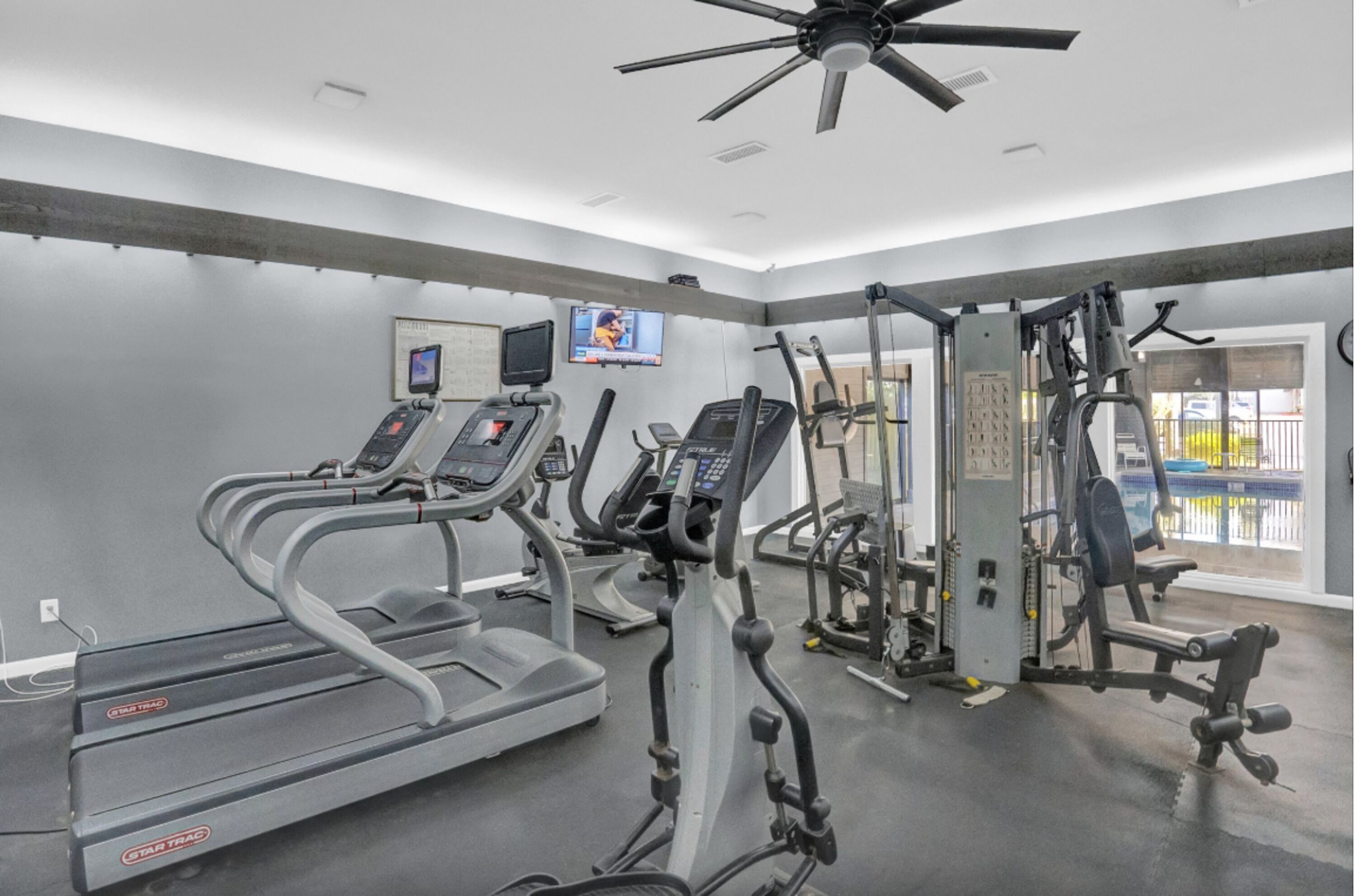 A gym with treadmills, elliptical machines, and weight equipment.