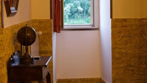A room with a window, a mirror, a globe, and a small table. - Vacation House Dolce Angelo 21, with view of Amphitheater, in the heart of the historic center (Sutri)