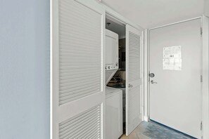 A room with a closed door, a white closet with louvered doors, and a small window. - Vibrant condo on the beach with 2 pools and hot tub (Miramar Beach)