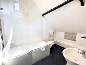 A modern bathroom with a glass shower enclosure, a bathtub, a sink, and a towel rack. - The George and Dragon Hotel (Sudbury)