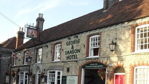 Un edificio tradizionale in mattoni con un cartello che recita 'George & Dragon Hotel'.