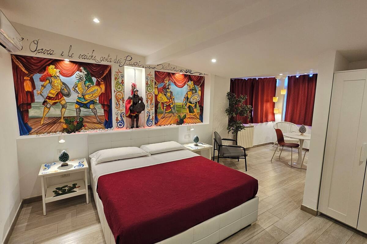 A hotel room with a bed, a desk, a chair, and a wardrobe.