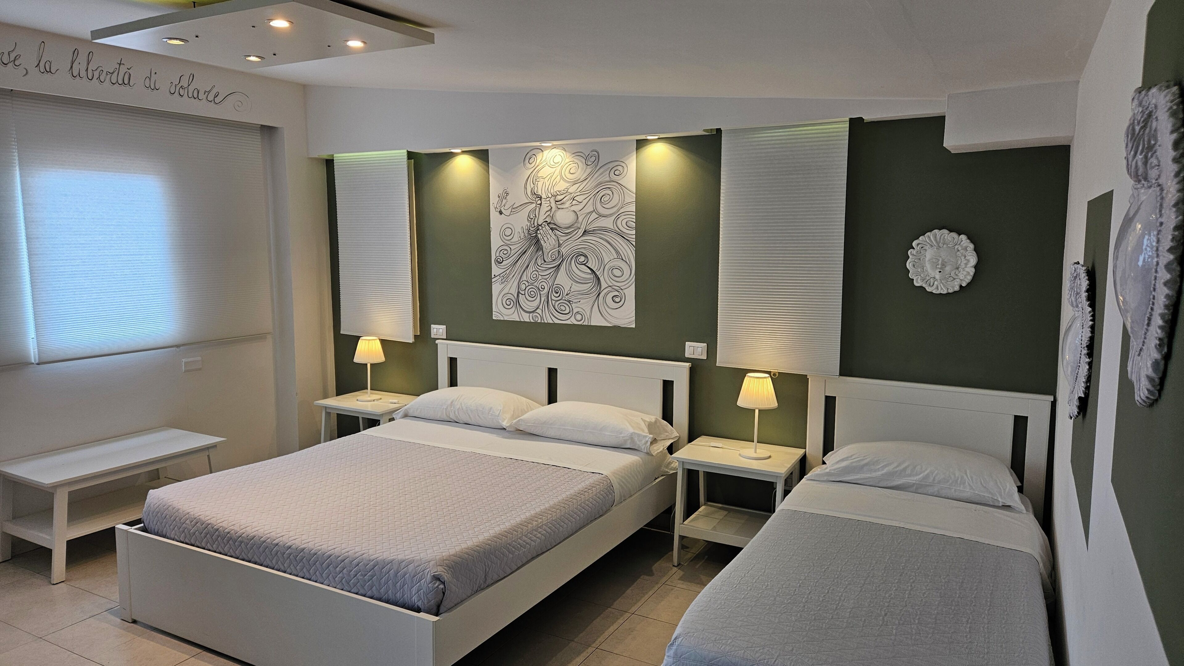 Una habitación de hotel con dos camas, lámparas de noche, un cuadro en la pared y una ventana con persianas.