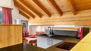 A kitchen with wooden beams, a sink, and a stove. - Apartment 'Ferienwohnung Gipfelblick' with Mountain View, Balcony and Wi-Fi (Oberau)