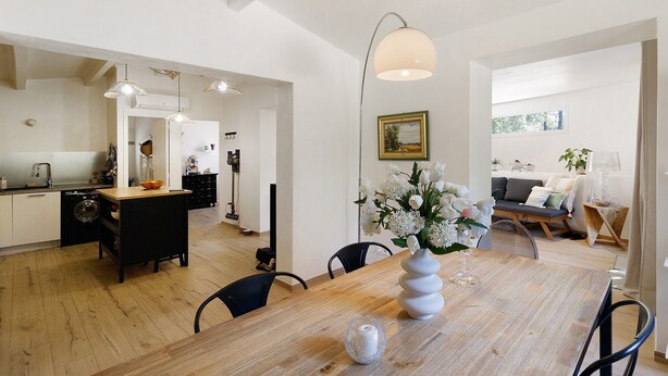 A modern kitchen with a dining area, wooden flooring, and pendant lighting. - Holiday Home 'Mer Et Montagne À Conca' with Mountain View, Private Terrace and Wi-Fi (Conca)