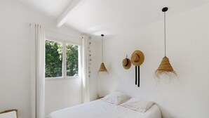 A bedroom with a bed, a window with curtains, and two wall-mounted lamps. - Holiday Home 'Mer Et Montagne À Conca' with Mountain View, Private Terrace and Wi-Fi (Conca)