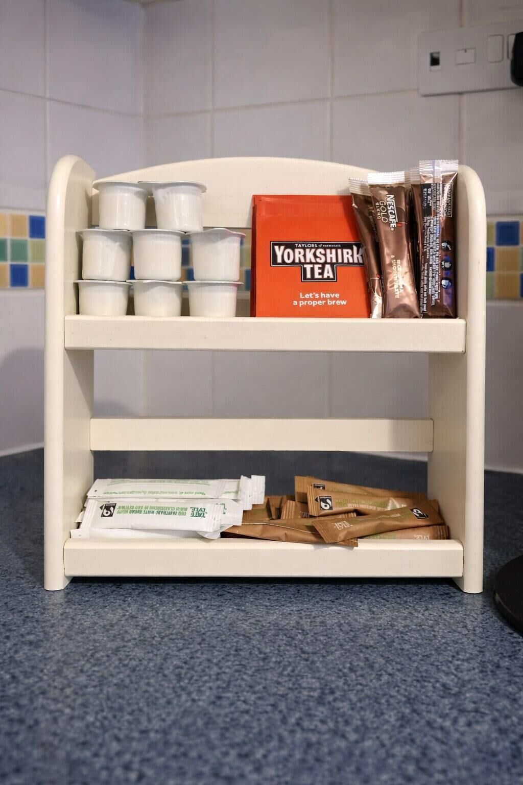 Une étagère blanche avec des boîtes et des sachets de thé.