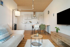 Un salon moderne avec un canapé, une table basse et un téléviseur fixé au mur.