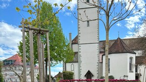 A garden with a variety of flowers and a church with a tower. - Panoramic View Holiday Apartment (Deggenhausertal)