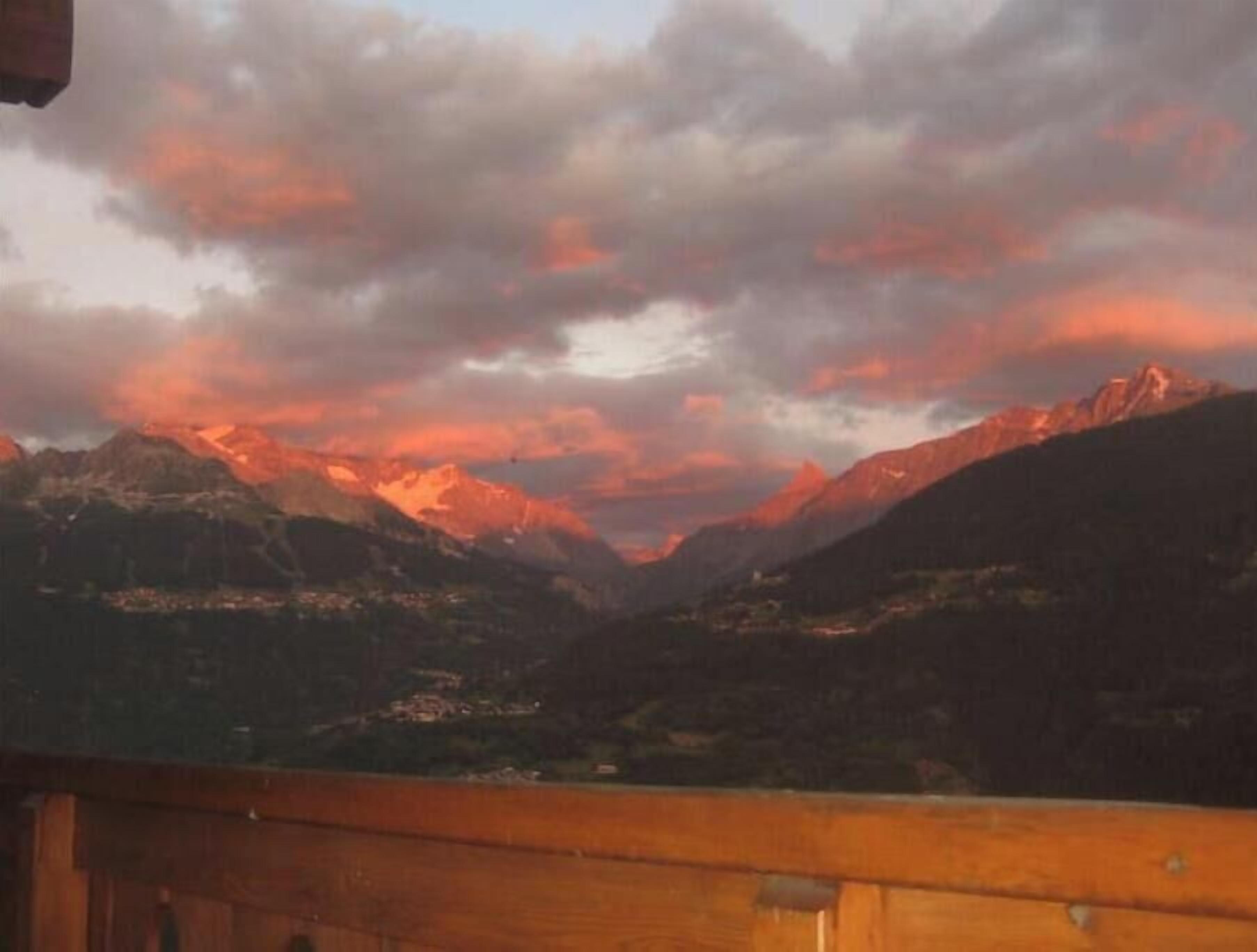 Un paysage montagneux avec une balustrade en bois sur un balcon.
