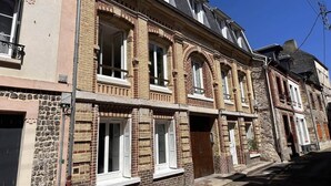 A row of traditional brick buildings with arched windows and a central entrance. - Duplex Chic et Confort (Fécamp)