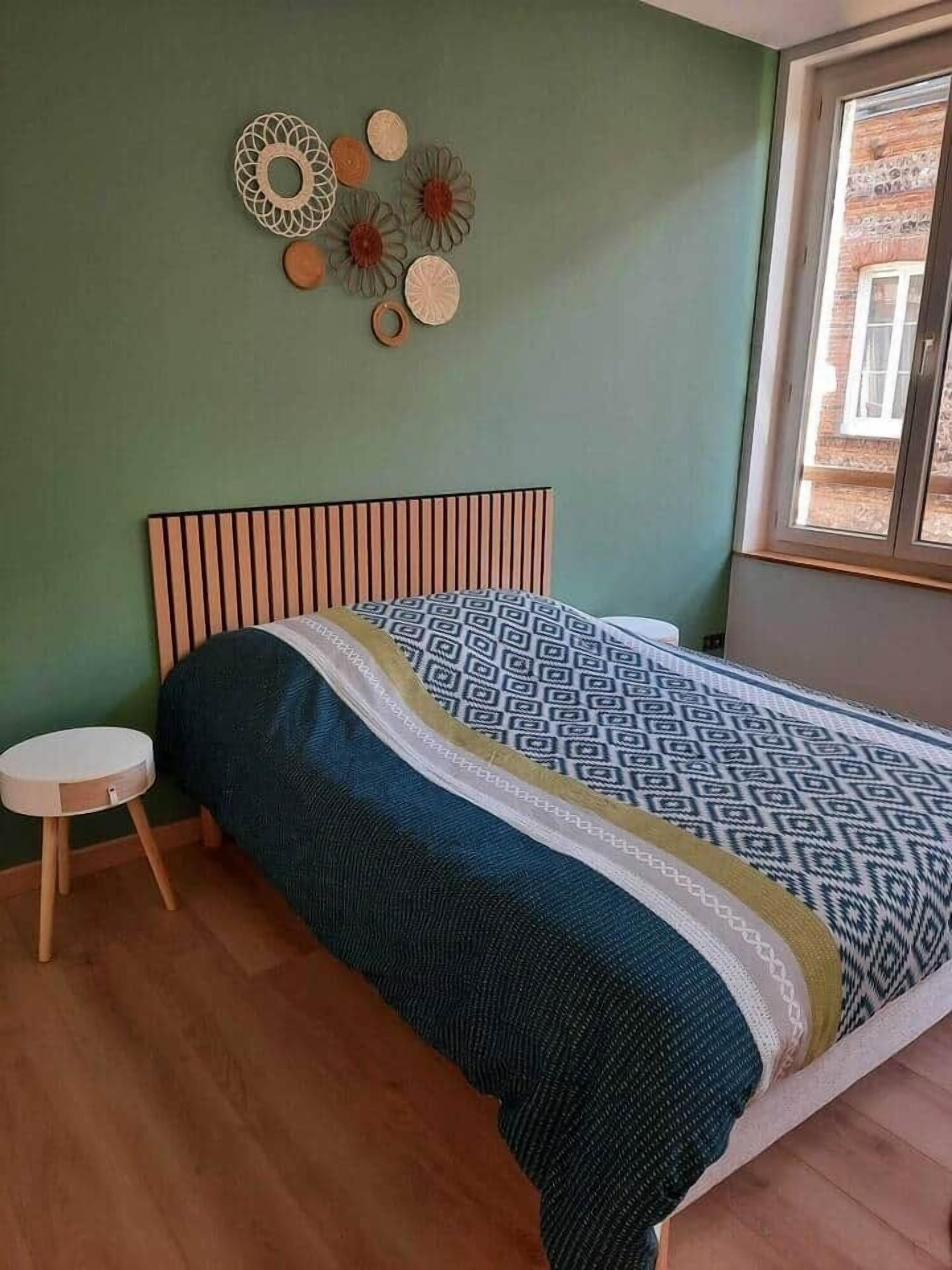 Une chambre à coucher avec un lit, une petite table ronde et une fenêtre.