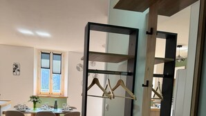 A modern kitchen with wooden cabinets, a dining area with a table and chairs, and a view of the outdoors through a window. - 6-person apartment (3bed) between beach and port (Fécamp)