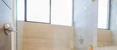 A modern bathroom with a shower, toilet, and vanity.