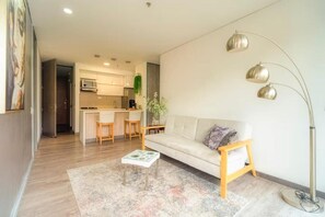 Un saló modern amb un sofà, taula de centre i làmpada de peu.