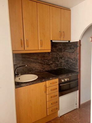 A kitchen with wooden cabinets, a granite countertop, a sink, a stove, and a dishwasher. - 🏖️ Your perfect summer in Roda de Berà! Pool + Beach + Parking 🚗 (CT)